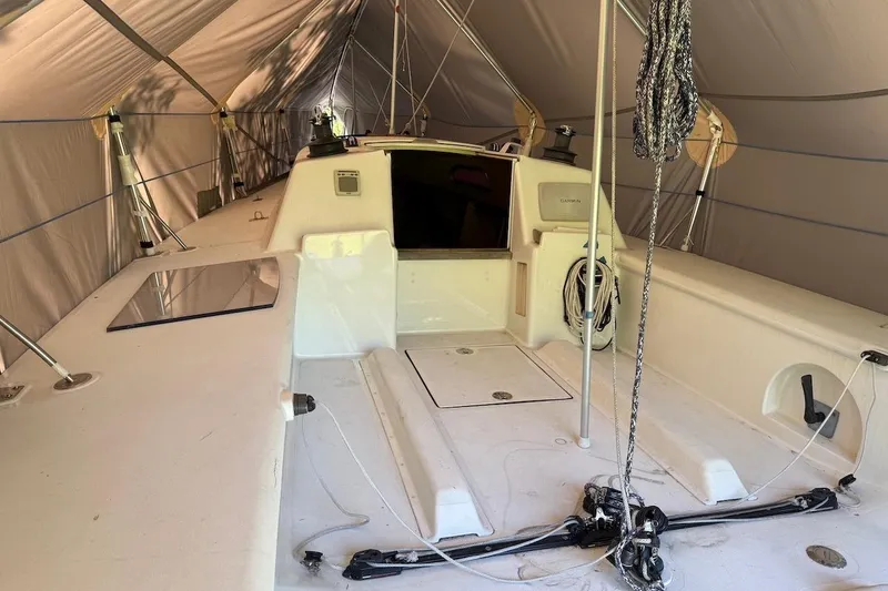 Slide: The Image of 2007 Hallett 33 boat interior under a protective tent, showcasing deck and rigging. - 65