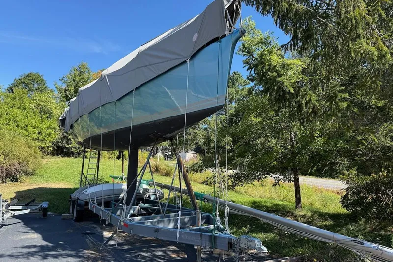 Slide: The Image of Covered 2007 Hallett 33 boat on trailer, surrounded by trees and greenery. - 9