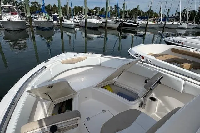 Slide: The Image of 2018 Robalo R222 Explorer boat docked in a marina, open storage compartments visible. - 14