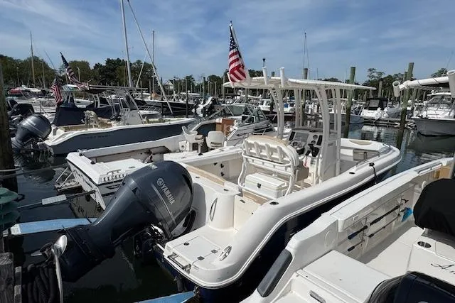 Slide: The Image of 2018 Robalo R222 Explorer boat docked in marina, featuring Yamaha outboard motor. - 18