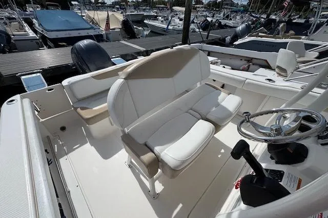 Slide: The Image of 2018 Robalo R222 Explorer boat interior with seating and steering wheel at marina. - 6