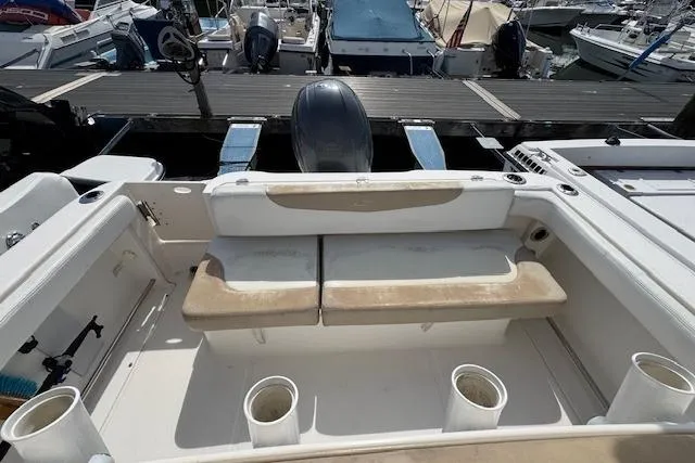 Slide: The Image of 2018 Robalo R222 Explorer boat interior with seating and cup holders at a marina. - 7