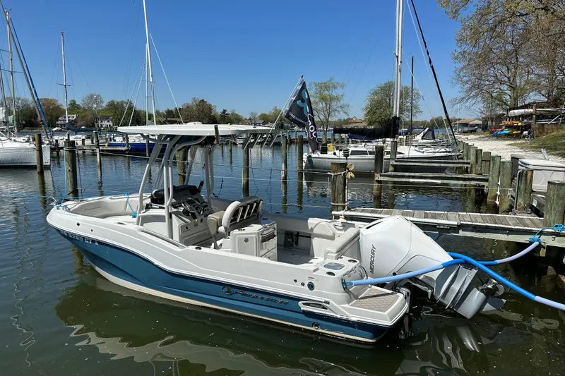 The Image of 2023 Finseeker 230cc boat docked in a marina with clear blue skies. - 1