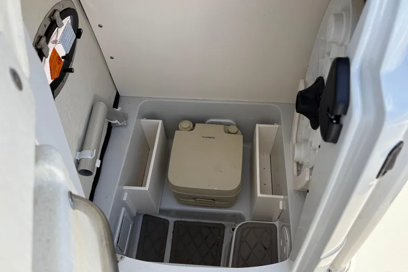 Slide: The Image of Interior of 2023 Finseeker 230cc boat featuring compact portable toilet setup. - 13
