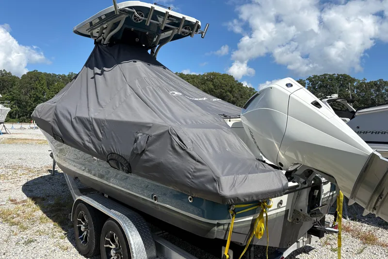 Slide: The Image of 2023 Finseeker 230cc boat covered, on trailer, with outboard motor, under blue sky. - 3