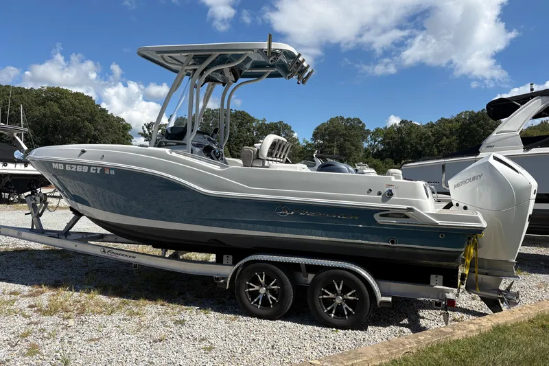 Slide: The Image of 2023 Finseeker 230cc boat on trailer, parked outdoors under a clear blue sky. - 4