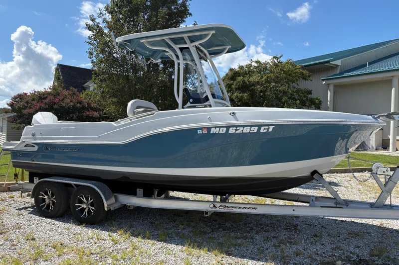 Slide: The Image of 2023 Finseeker 230cc boat on trailer, parked outdoors under a clear sky. - 5