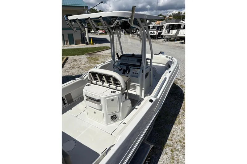 Slide: The Image of 2023 Finseeker 230cc boat with center console and T-top, parked outdoors. - 6
