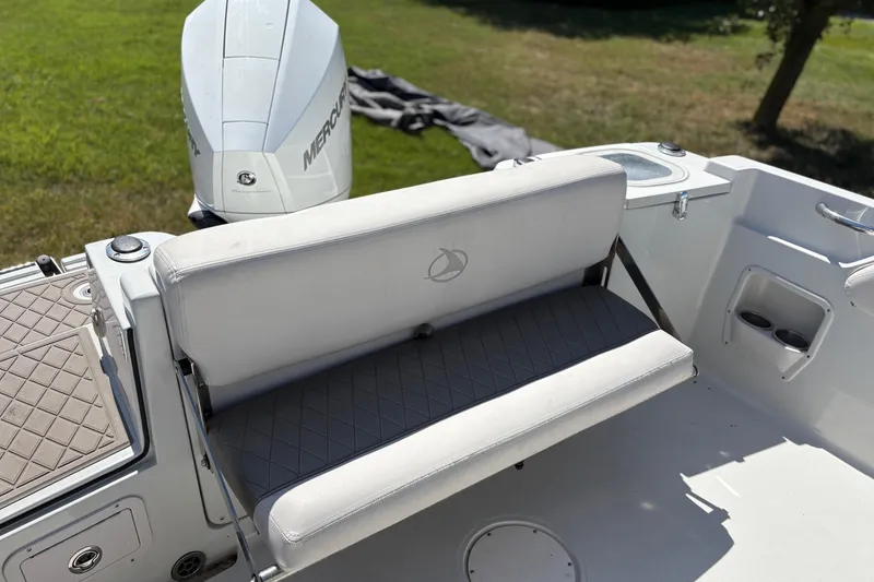 Slide: The Image of 2023 Finseeker 230cc boat interior with cushioned seating and Mercury engine. - 9