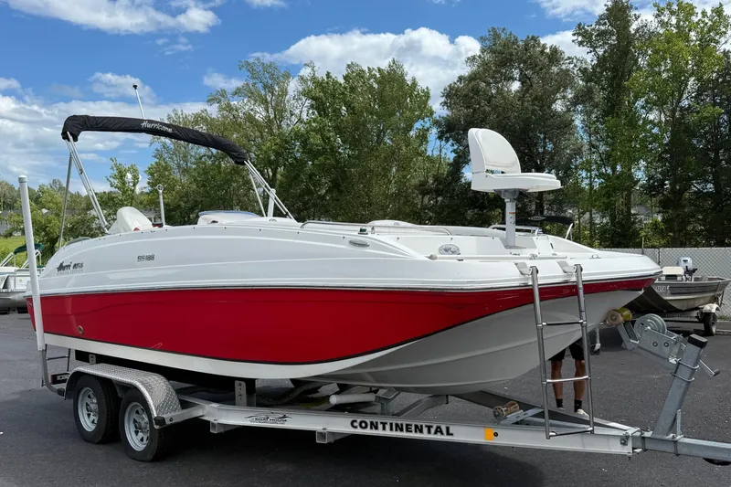 The Image of 2019 Hurricane SunDeck Sport 188 OB boat on trailer, red and white design. - 0