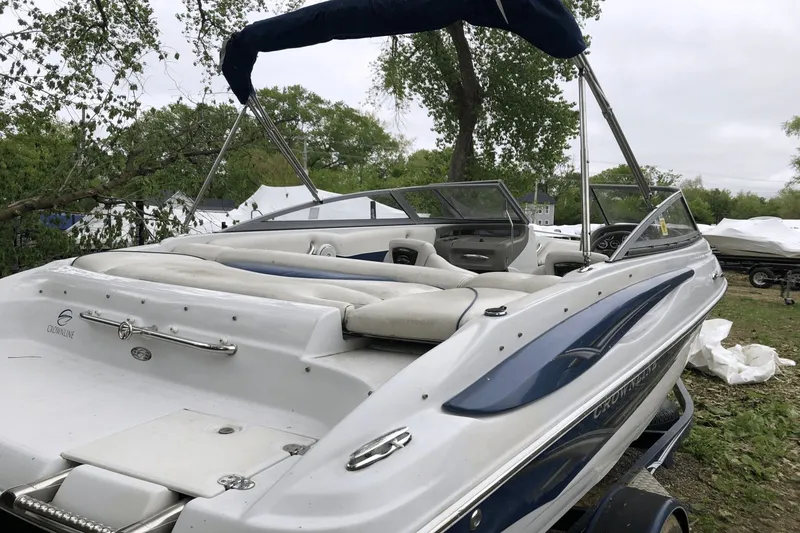 Slide: The Image of 2008 Crownline 19 SS boat with white and blue exterior, parked outdoors. - 11