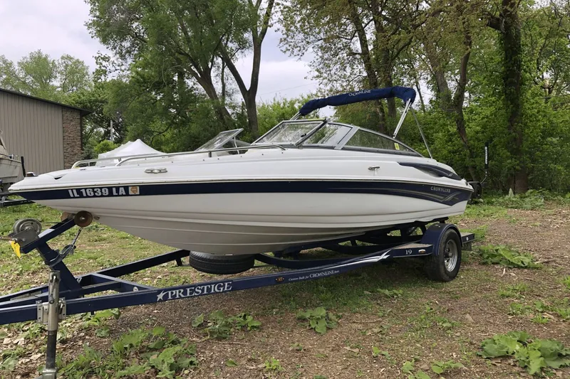 Slide: The Image of 2008 Crownline 19 SS boat on trailer, parked outdoors with trees in background. - 9
