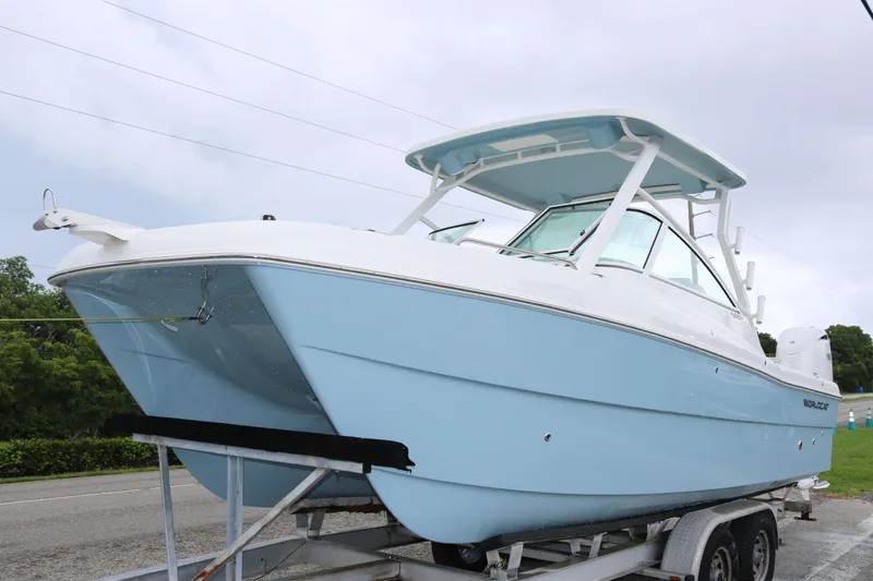 The Image of 2026 World Cat 230 DC boat on trailer, light blue hull, overcast sky. - 0