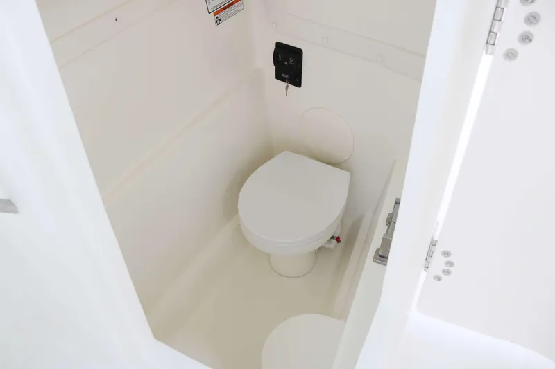 Slide: The Image of 2026 World Cat 230 DC boat interior with compact marine toilet. - 11