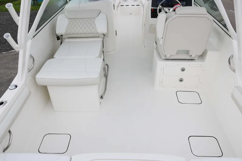 Slide: The Image of 2026 World Cat 230 DC boat interior with white seating and storage compartments. - 14