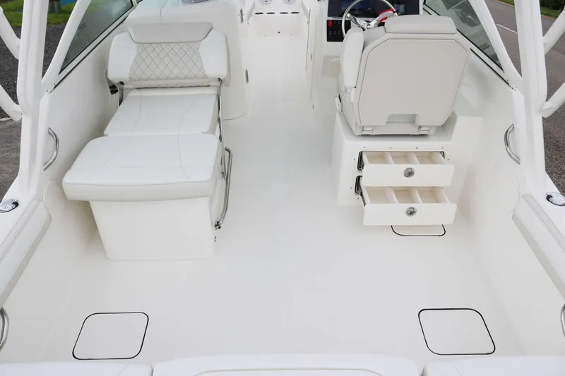 Slide: The Image of 2026 World Cat 230 DC interior with white seating and storage drawers. - 15