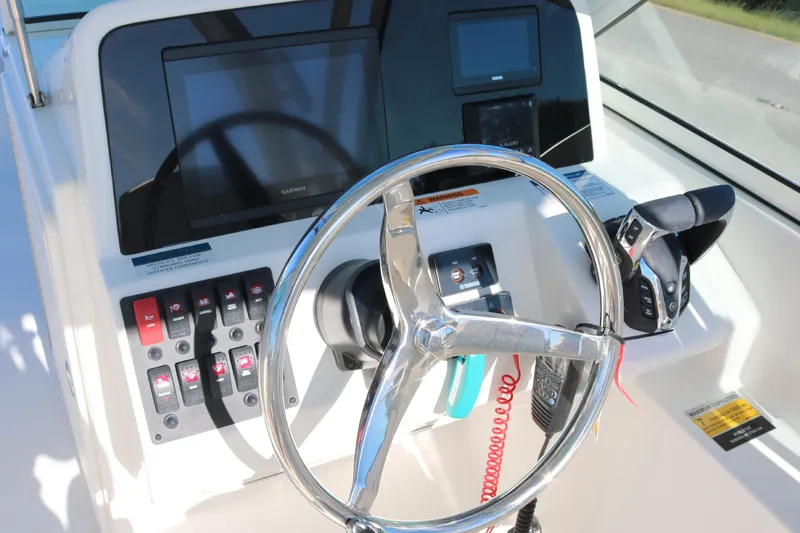 Slide: The Image of Helm of 2026 World Cat 230 DC boat with steering wheel and control panel. - 6