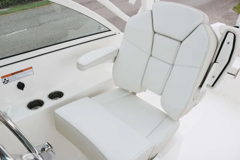 Slide: The Image of White leather seat on 2026 World Cat 230 DC boat, featuring cup holders and armrest. - 7