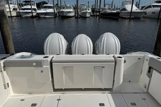 Slide: The Image of 2025 Pursuit DC 365 Dual Console boat with triple engines docked at marina. - 11