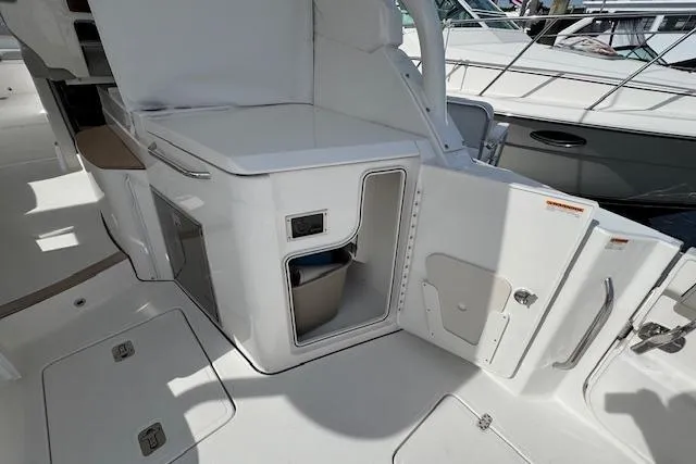 Slide: The Image of 2025 Pursuit DC 365 Dual Console boat interior with open storage compartments. - 16
