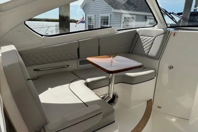 Slide: The Image of 2025 Pursuit DC 365 Dual Console interior with elegant seating and wooden table. - 17