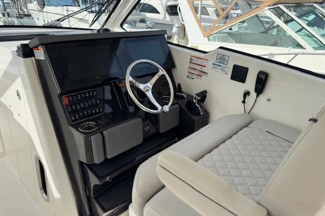Slide: The Image of 2025 Pursuit DC 365 Dual Console boat interior with steering wheel and control panel. - 18