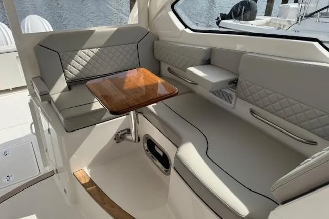 Slide: The Image of 2025 Pursuit DC 365 Dual Console interior with elegant seating and wooden table. - 20