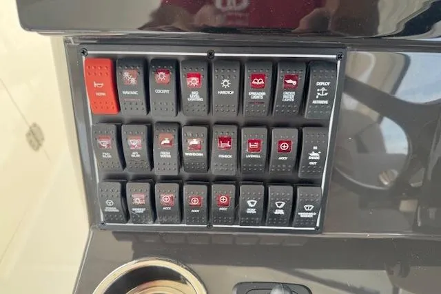 Slide: The Image of Control panel of 2025 Pursuit DC 365 Dual Console boat with labeled switches. - 23