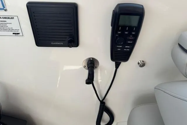 Slide: The Image of 2025 Pursuit DC 365 Dual Console boat dashboard with Garmin speaker and radio handset. - 26