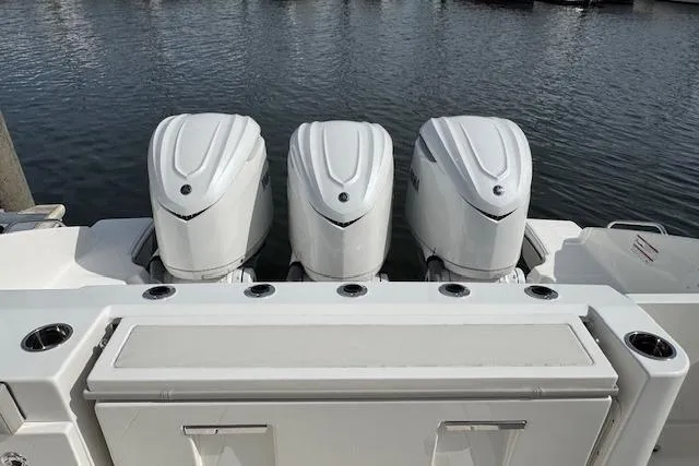 Slide: The Image of 2025 Pursuit DC 365 Dual Console with triple outboard engines on water. - 29