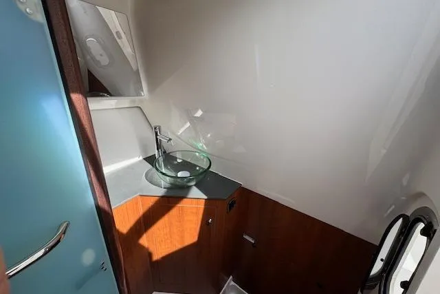 Slide: The Image of 2025 Pursuit DC 365 Dual Console boat interior with modern sink and wooden cabinetry. - 34