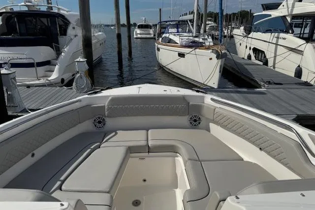 Slide: The Image of 2025 Pursuit DC 365 Dual Console boat interior at marina, featuring spacious seating. - 35