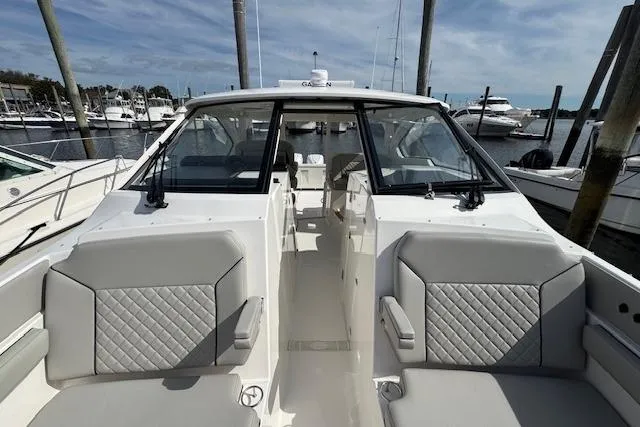 Slide: The Image of 2025 Pursuit DC 365 Dual Console boat docked at marina, featuring spacious seating and sleek design. - 38