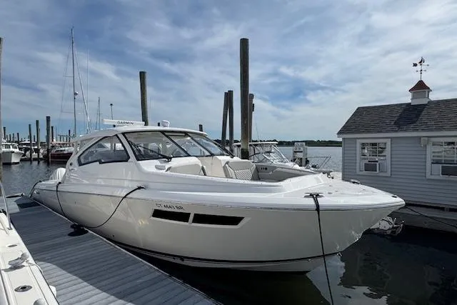 Slide: The Image of 2025 Pursuit DC 365 Dual Console boat docked at marina under blue sky. - 4