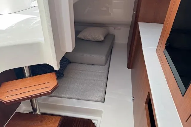 Slide: The Image of 2025 Pursuit DC 365 Dual Console cabin interior with cozy bedding and wooden accents. - 43