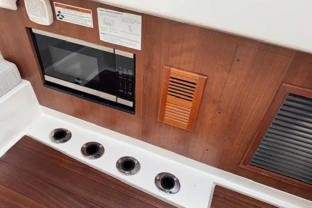 Slide: The Image of Interior of 2025 Pursuit DC 365 Dual Console with microwave and wood paneling. - 44