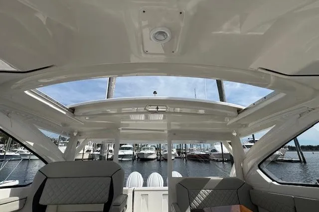 Slide: The Image of Interior view of 2025 Pursuit DC 365 Dual Console boat with marina background. - 48