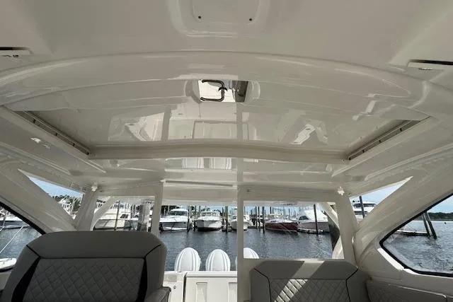 Slide: The Image of 2025 Pursuit DC 365 Dual Console interior with marina view, featuring sleek design and comfortable seating. - 49