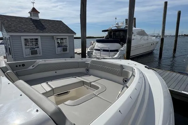 Slide: The Image of 2025 Pursuit DC 365 Dual Console boat docked, featuring spacious seating and elegant design. - 5