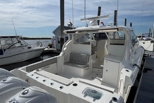 Slide: The Image of 2025 Pursuit DC 365 Dual Console boat docked, featuring spacious deck and modern design. - 9