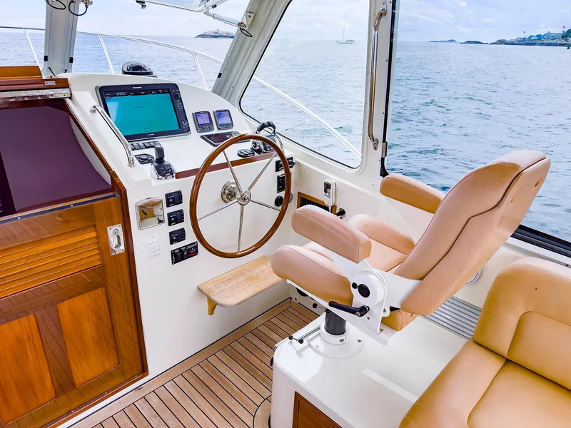 Slide: The Image of 2012 MJM 40z Downeast helm with wooden wheel, leather seat, and navigation equipment. - 12