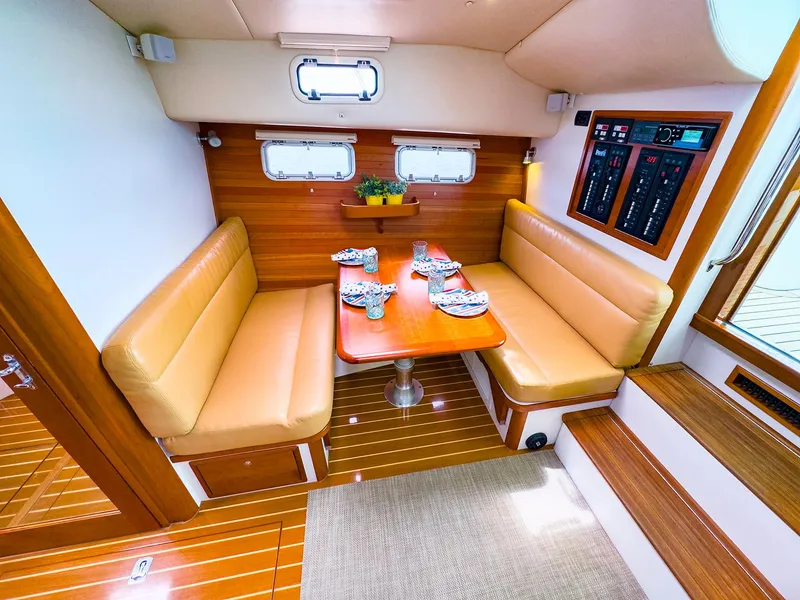 Slide: The Image of 2012 MJM 40z Downeast yacht interior with tan seating and wooden table. - 22