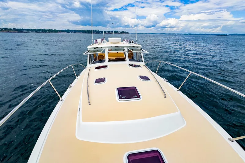 Slide: The Image of 2012 MJM 40z Downeast yacht on open water, showcasing sleek deck design. - 4