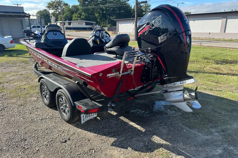 Slide: The Image of 2024 Tracker Pro Team 195 TXW Tournament Edition boat with Mercury 150 engine, parked outdoors. - 2