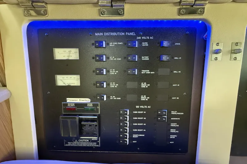 Slide: The Image of Main distribution panel on 2018 Sea Ray Sundancer 460 yacht, featuring various switches and meters. - 32