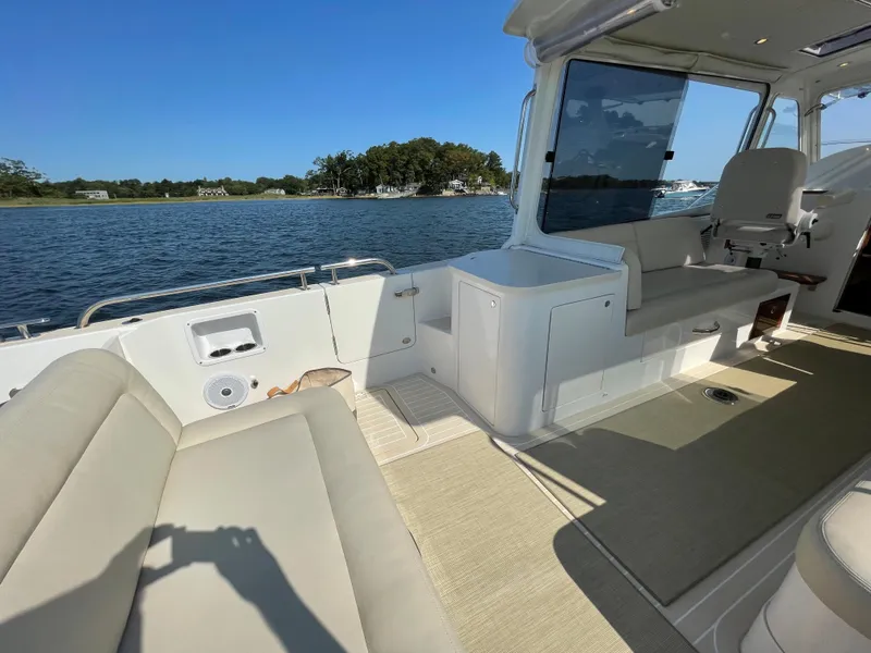 Slide: The Image of 2020 MJM 35z boat interior with seating, overlooking calm waters and shoreline. - 12