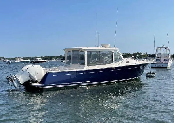 Slide: The Image of 2020 MJM 35z boat with dual outboard engines on calm water. - 2