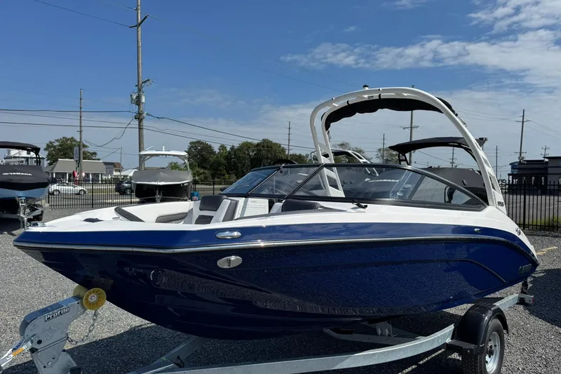 Slide: The Image of 2026 Yamaha Boats 195S, sleek blue and white design, on a trailer in a lot. - 3