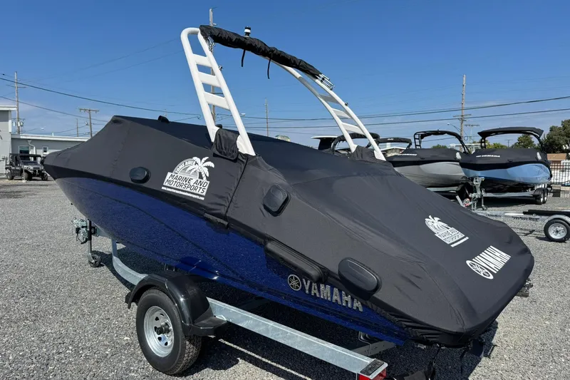 Slide: The Image of 2026 Yamaha Boats 195S covered on trailer, parked outdoors under blue sky. - 8