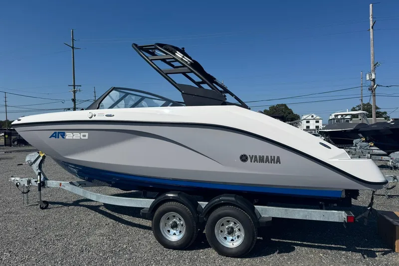 Slide: The Image of 2026 Yamaha Boats AR220 on trailer, sleek design under clear blue sky. - 2